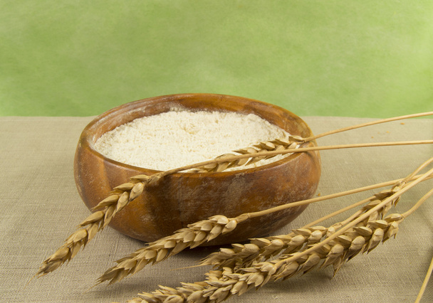 Flour in a wooden bowl with ears of wheat - Valokuva, kuva