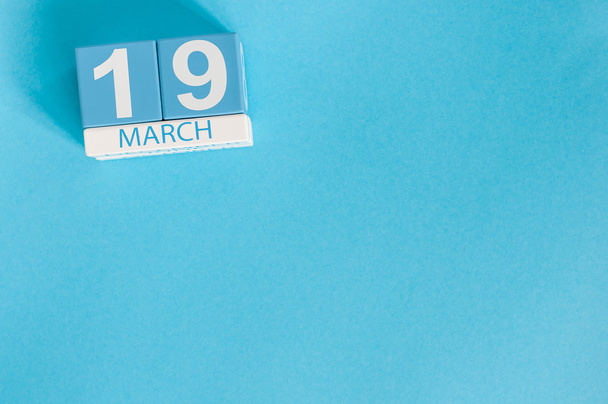 19. března. Obrázek 19. Barevný kalendář z března s květinou na modrém pozadí. Jarní den. Hodina země a mezinárodní klienti den - Fotografie, Obrázek