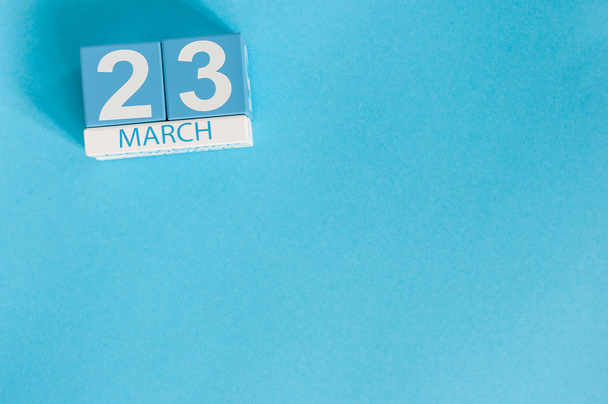 23. března – 3. obraz dřevěného kalendáře z března na modrém pozadí. Jarní den, prázdné místo pro text - Fotografie, Obrázek