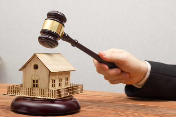 Auction, Real Estate concept. Hand with judge gavel and house model - 写真・画像