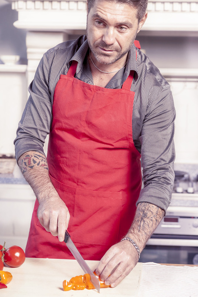handsome young adult in modern kitchen while preparing vegetable - Fotó, kép