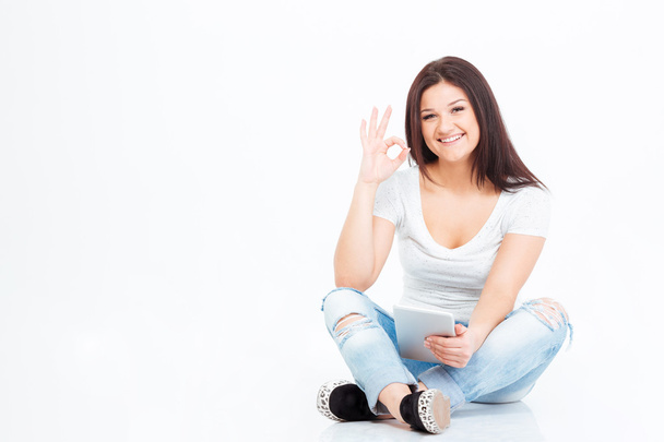 Woman sitting on the floor and showing ok sign - Photo, image