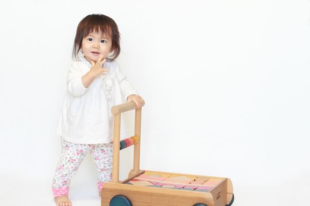Japanse babymeisje duwen een kar (1 jaar oud) - Foto, afbeelding