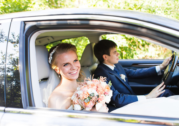 Sposa e sposo dentro una macchina. Sono felici.
. - Foto, immagini
