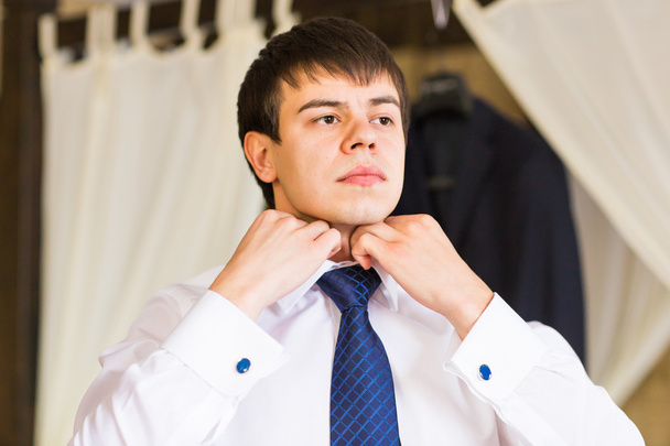 Businessman putting on a necktie - Фото, зображення