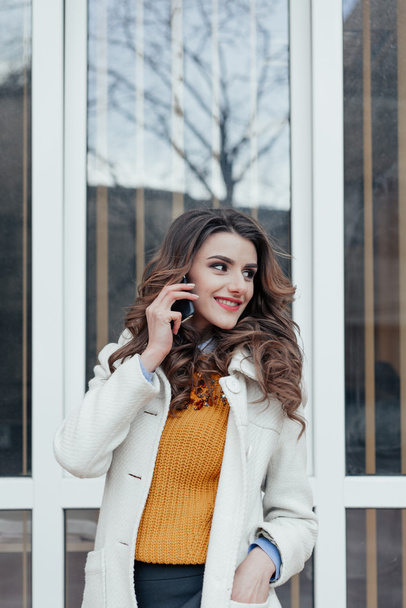 Şehirdeki bir telefon ile güzel kız - Fotoğraf, Görsel