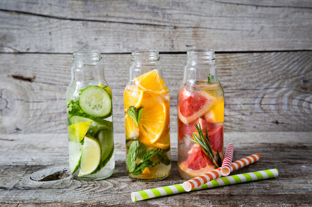 Selection of infused water in glass bottles, rustic wood background - Photo, Image