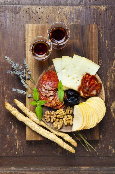 Snacks on a clay plate with wine Marsala . on wooden background. - Foto, Imagen