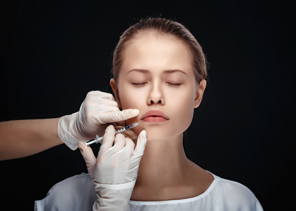Portrait of young Caucasian woman getting cosmetic injection - Foto, Imagen