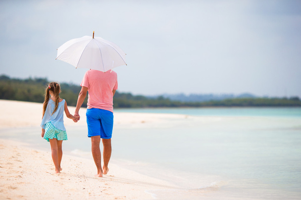 Вид семьи на пляж с зонтиком
 - Фото, изображение