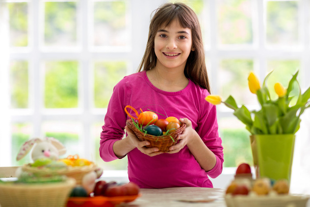 Beautiful girl with basket of colorful eggs - Photo, image