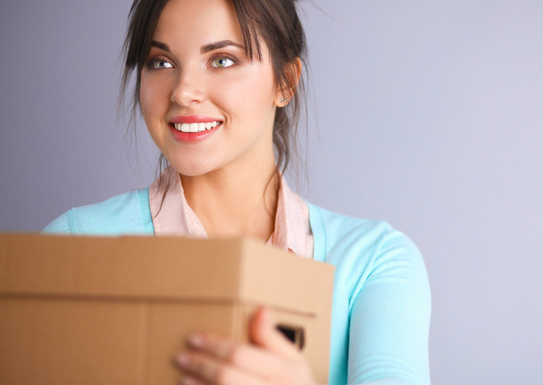 Portrait of pretty woman holding a box - Photo, image