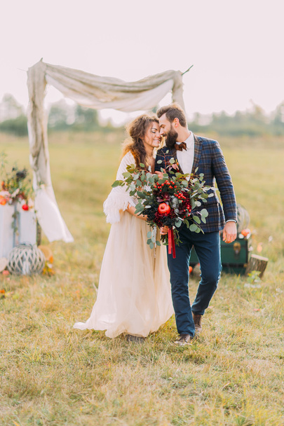 Stylish newlyweds holding each other on the field - Valokuva, kuva