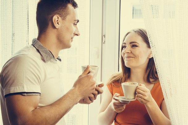 young couple drinking tea or coffee at home - Fotó, kép