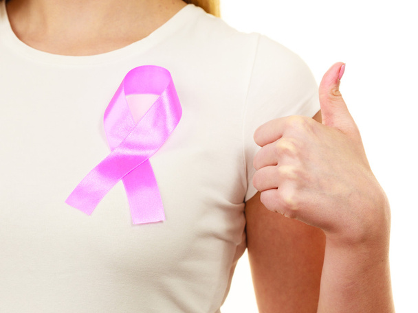 Closeup pink cancer ribbon on woman chest  - Photo, Image