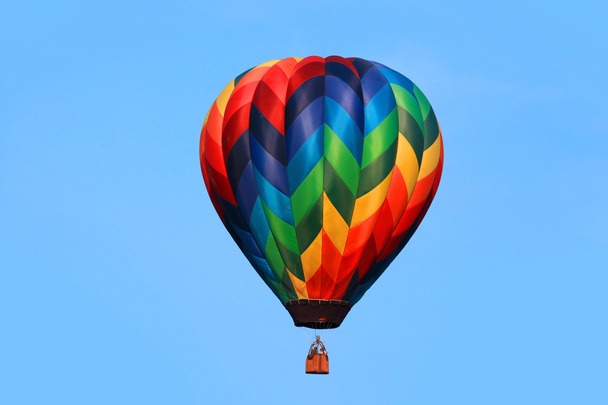 Kleurrijke hete luchtballon tegen blauwe achtergrond - Foto, afbeelding