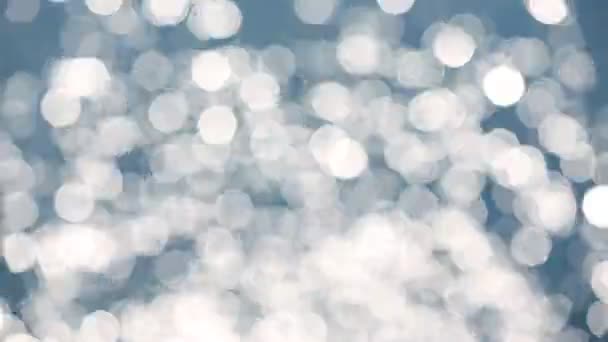 Bokeh achtergrond van blauwe zeewater met reflecties van de zon - Video