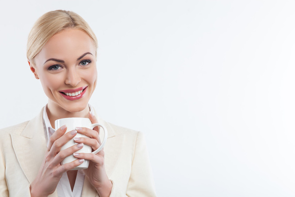 Attractive blond lady is drinking hot coffee - Foto, Imagen