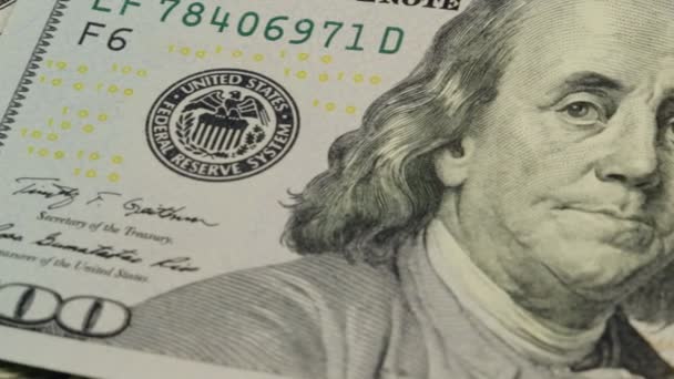現金の背景。100米ドル札上のベンジャミン・フランクリンの肖像画を閉じると、画像が回転します - 映像、動画