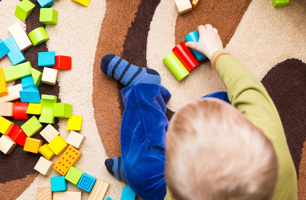 Small child playing with wooden blocks - Zdjęcie, obraz