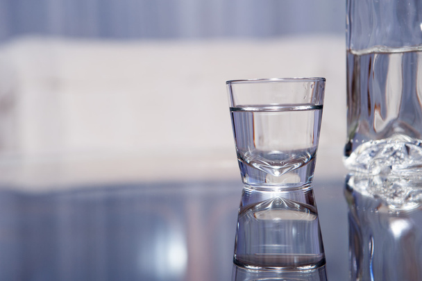 Vodkalasi lasipöydällä
 - Valokuva, kuva