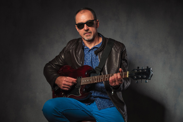mature rocker in leather jacket playing electric guitar - Fotoğraf, Görsel