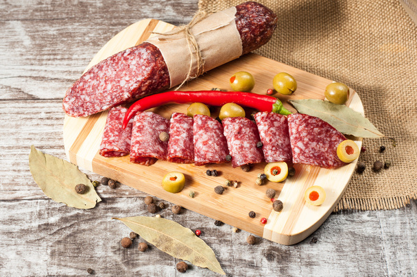 Italialainen salami oliivien ja mausteiden kanssa puupohjalla
 - Valokuva, kuva