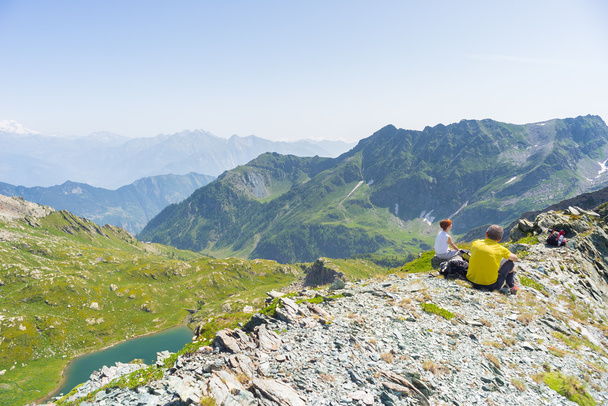 Wandelaars die rusten op de top van de berg, expansieve panorama - Foto, afbeelding
