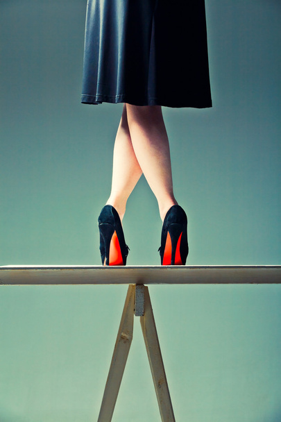 schlanke weibliche Beine auf dem Tisch gekreuzt - Foto, Bild
