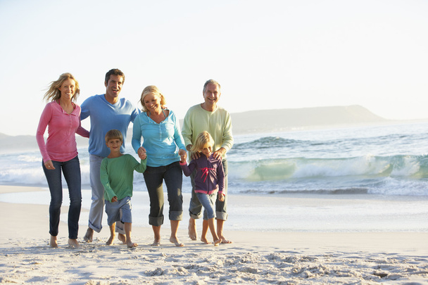 Family On Holiday Walking Along Beach - Foto, imagen