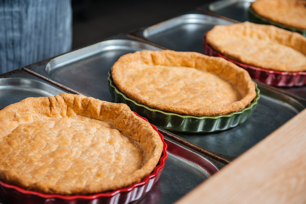 Cooked pie bases in baking pans on the kitchen - Foto, imagen
