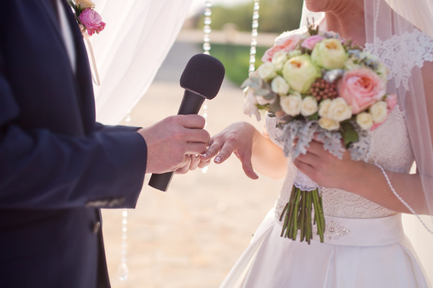 Жених носит обручальное кольцо на пальце невесты
 - Фото, изображение