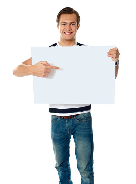 Portrait of young man pointing at blank signboard - Fotografie, Obrázek
