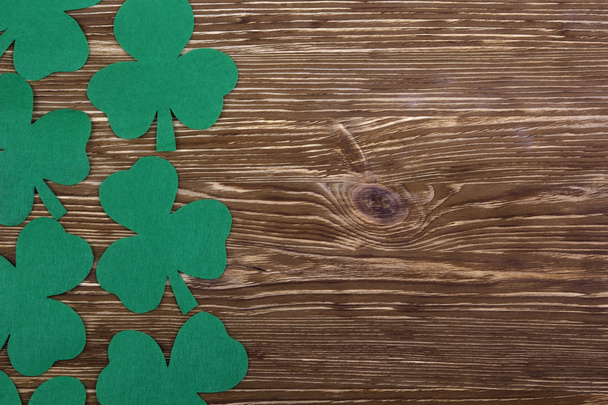 Fabric green clover leaves on wooden background. - Photo, Image