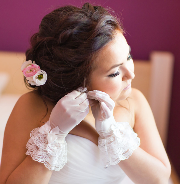 elegante Braut setzt Ohrringe Nahaufnahme, Vorbereitungen für die Hochzeit - Foto, Bild