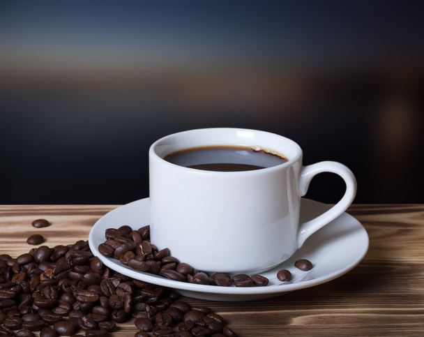 Κόκκους καφέ και καφέ σε λευκό Κύπελλο στο ξύλινο τραπέζι απέναντι από ένα  - Φωτογραφία, εικόνα