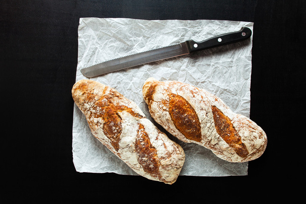 dark bread and a knife for cutting bread - Foto, afbeelding