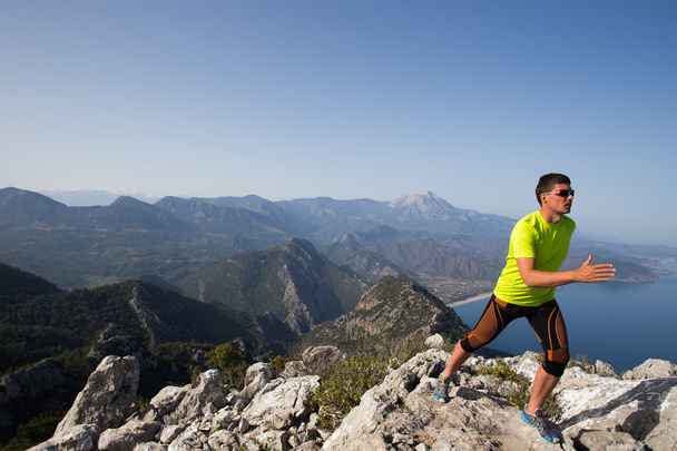 Trail Runner trainiert Ausdauerlauf auf felsigen Bergen gelben Sandpfad in der Natur. - Foto, Bild