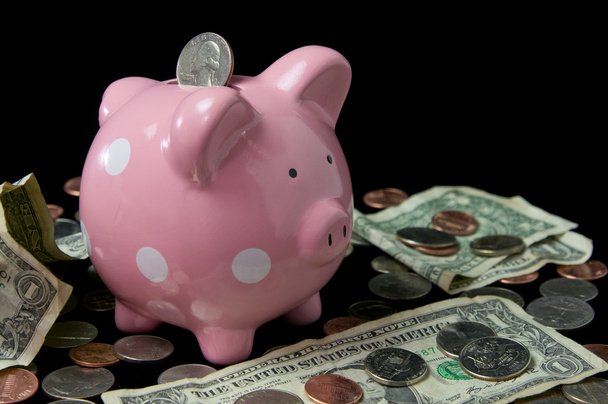 roze polka dot piggy bank met contant geld & munten - Foto, afbeelding