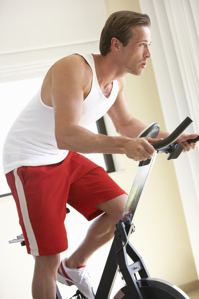 Young Man On Exercise Bike  - Foto, afbeelding