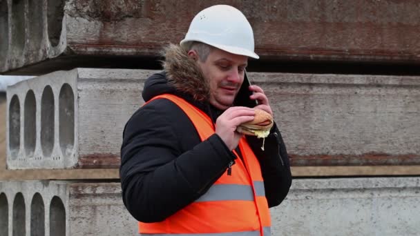 Worker with smartphone and hamburger at outdoor - 映像、動画