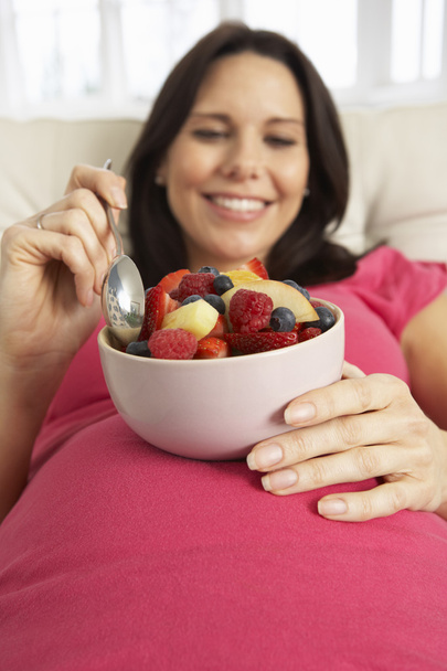 Pregnant Woman Eating Bowl Of Fruit Salad  - Foto, afbeelding