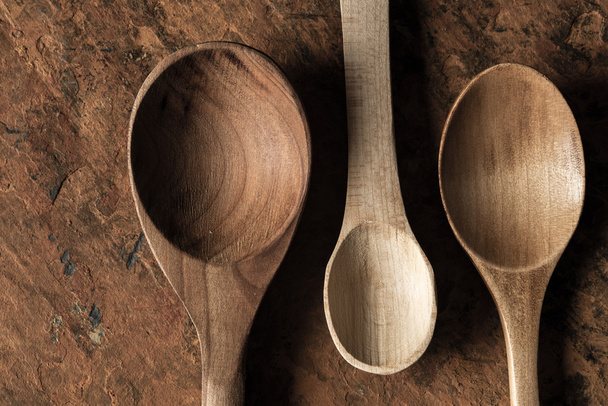 Wooden spoons set on the  stone background - Foto, Bild