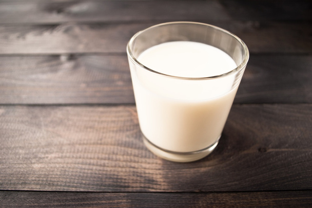 Glass of milk on wooden background - Фото, изображение