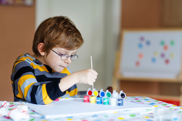 Little kid boy drawing with colorful watercolors indoors - Fotografie, Obrázek