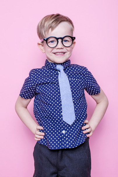 Stylish boy in shirt and glasses with big smile. School. Preschool. Fashion. Studio portrait over pink background - Фото, зображення