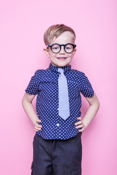 Stylish boy in shirt and glasses with big smile. School. Preschool. Fashion. Studio portrait over pink background - Foto, afbeelding