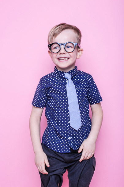 Little adorable kid in tie and glasses. School. Preschool. Fashion. Studio portrait over pink background - Photo, Image