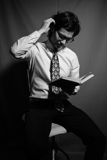 Young man reading a book with glasses. - Fotó, kép