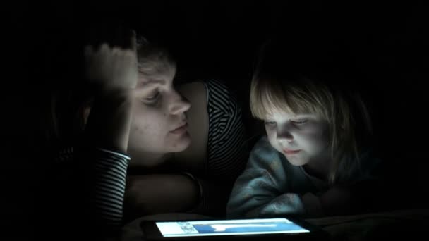 Mutter und Tochter genießen die Tablette nachts - Filmmaterial, Video